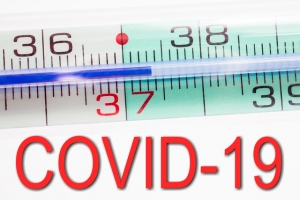 COVID-19 text and thermometer showing an elevated body temperature