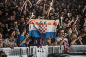 People shouting and cheering while holding flag in Zagreb, Croatia 