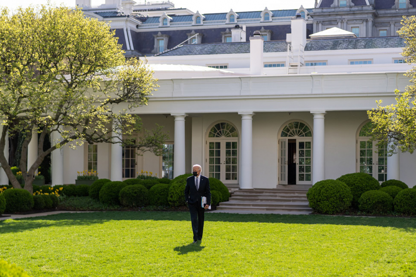 President Joe Biden walks across the Rose Garden of the White House.