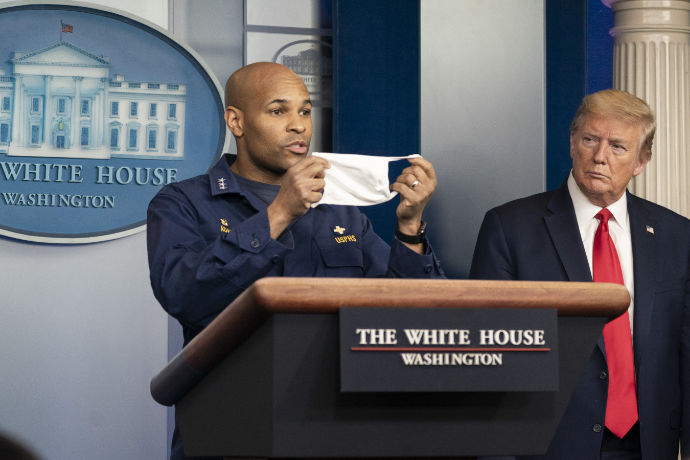 Donald J. Trump listens as U.S. Surgeon General Jerome Adams delivers remarks and urges citizens to wear masks in public at the coronavirus (COVID-19) update briefing Wednesday, April 22, 2020